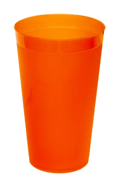 Orange plastic glass for juice, isolated on white background — Zdjęcie stockowe